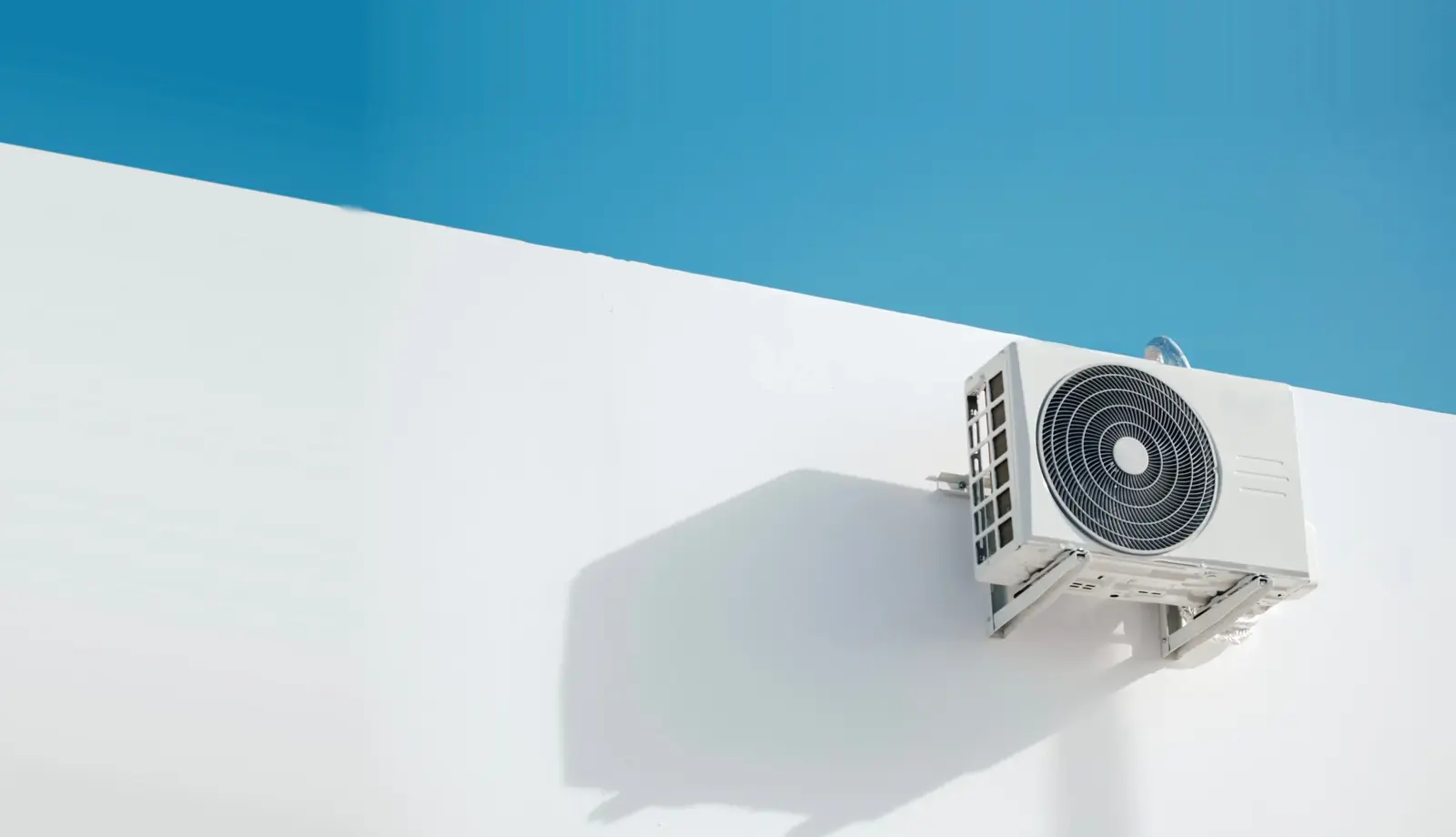 Pompe à chaleur installée sur une façade blanche — aides à la rénovation énergétique